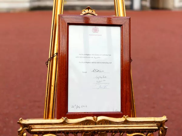 Un caballete se encuentra en el patio de Buckingham Palace anunciando el nacimiento del Príncipe George