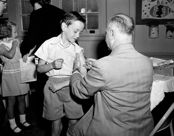 El hijo del cirujano general de EE. UU. Leonard McCormick 'Bobo' Scheele recibe la vacuna contra la polio en mayo de 1955. Byron Rollins/AP Photo