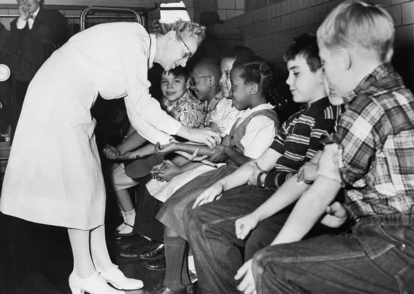 Una enfermera prepara a los niños de escuela primaria para una inyección de vacuna contra la polio. Bettmann / Contributor / Getty Images